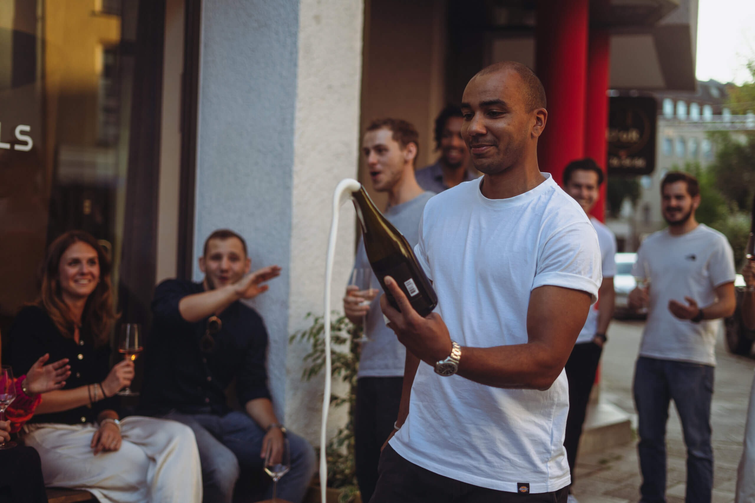 Dude mit frisch sabrierter Schaumweinflasche outdoor